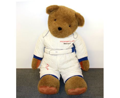 Motor racing interest, a very large teddy bear wearing a Porsche motor sport padded suit, probably used as a pit promotional 