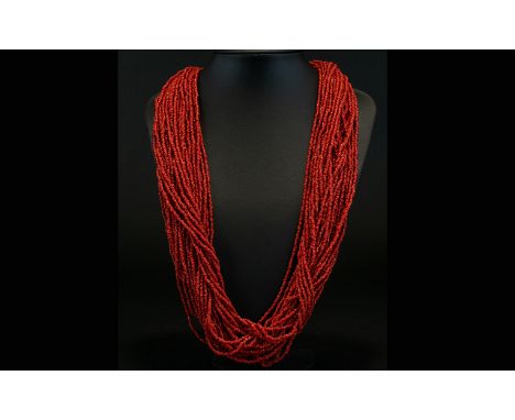 A Multi-Strand Coral Necklace. Vintage rope twist necklace fashioned  from appox twenty two strands of coral seed beads. Tota
