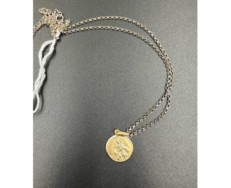 A 9ct gold St Christopher (Approximate weight 2g) on a separate silver chain.