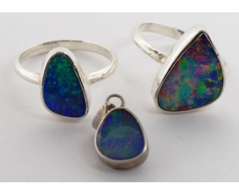 Opal and silver jewellery group Three free form doublet black opals set in two sterling silver rings and a pendant. Approx ri