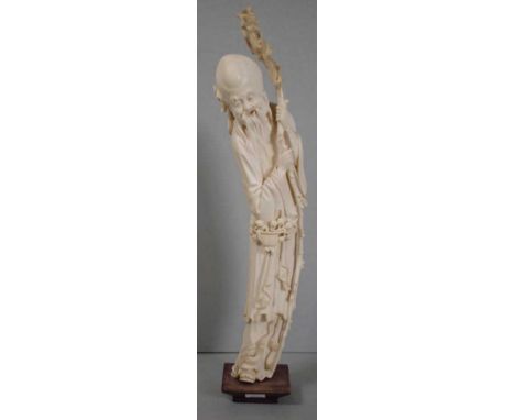 Chinese late Qing (1900-12) ivory Shou Lao figure depicted in a standing position leaning against his stick, mounted on part 