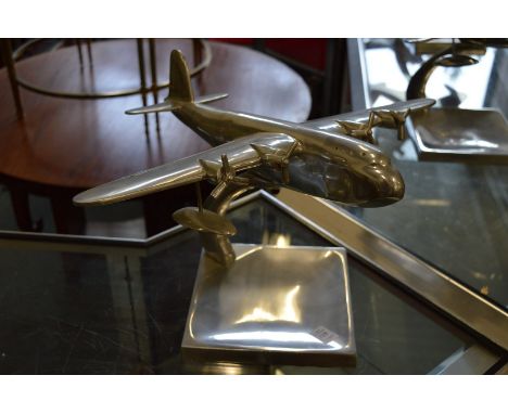 An aluminium model of an aeroplane on stand.