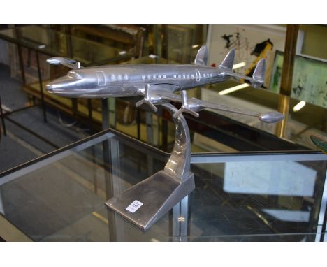 An aluminium model of an aeroplane on stand.