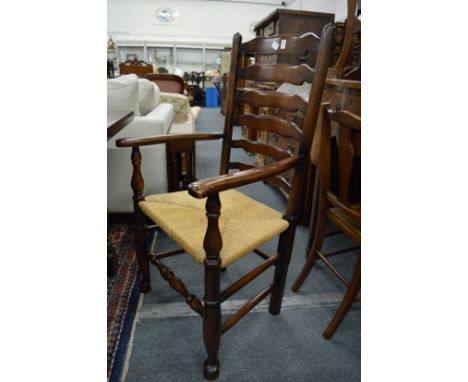 A good set of ten oak and rush seated ladder back dining chairs, two with arms.