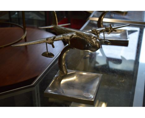 An aluminium model of an aeroplane on stand.