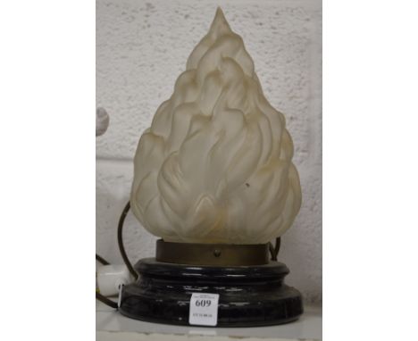 A table lamp with flaming torch glass shade.