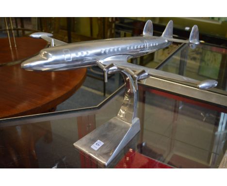 An aluminium model of an aeroplane on stand.