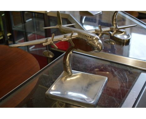 An aluminium model of an aeroplane on stand.