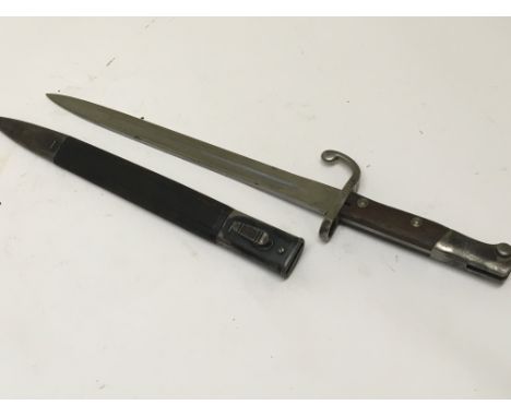 A German bayonet possible 1902 pattern with a hook quilon steel and wood grip. Leather and steel scabbard makers name stamped