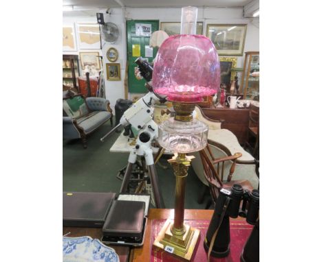 OIL LAMP, brass column base oil lamp with cranberry glass shade in clear glass reservoir 