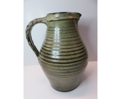 LEACH POTTERY; A larged ribbed water jug on a brown ground with Leach pottery marks to base. Aprrox 12" heigh.
