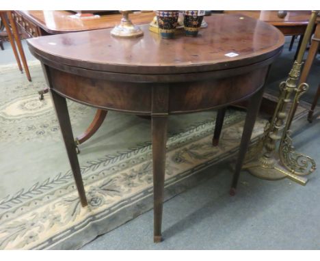 GEORGIAN DEMI-LUNE CARD TABLE, cross banded mahogany card table and tapering square section legs (requires restoration)