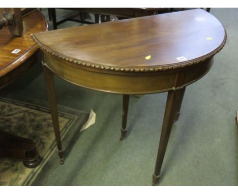 DEMI-LUNE CARD TABLE, mahogany fold top card table with tapering square section legs with brass castors, 33" width 