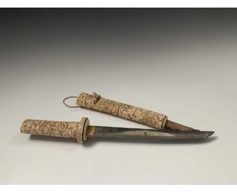 A Japanese ivory tanto, Meiji Period, the scabbard and hilt carved with stylised dragons amongst cloud scrolls, length 39.5cm