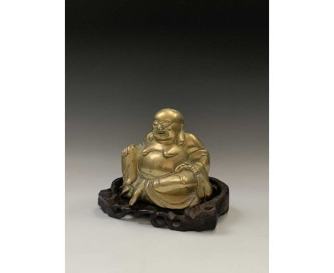 A Chinese brass model of a seated buddha, early 20th century, on a carved wood stand, total height 22cm, width 27cm, depth 18