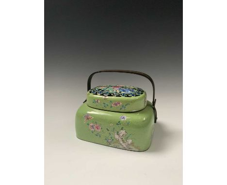 A Chinese enamel hand warmer, early 20th century, with brass handle, the pierced cover with colourful flowerheads and leaves,