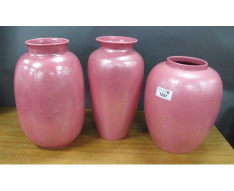 Poole Calypso Lustre Pottery Vases, with mottled decoration to pink ovoid bodies, varying shapes, the tallest 25.5cm high. (3
