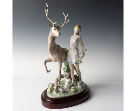 A glossy figure of a huntress holding a bow and arrows, surrounded by sweet forest animals. Lladro backstamp. This item has i