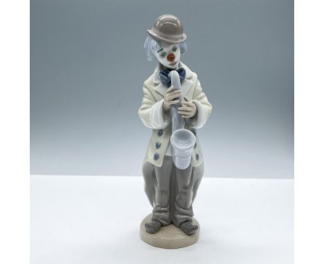 A glossy figure depicting a clown in an oversized jacket with a gloomy expression, holding a saxophone. Lladro backstamp. Inc