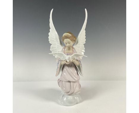 An angel in a pink robe releases a white dove from her hands, watching it take flight gracefully. Lladro backstamp. This item