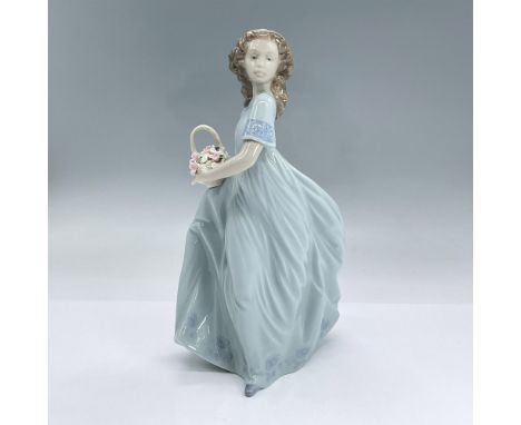 Glossy porcelain figure of a young lady kneeling in a long light blue dress holding a basket of flowers. Lladro backstamp. In