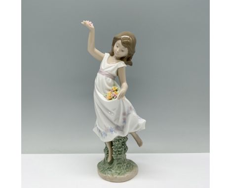 A girl in a white sundress holds a bouquet of flowers, using her dress as a makeshift basket. Lladro backstamp. This item has