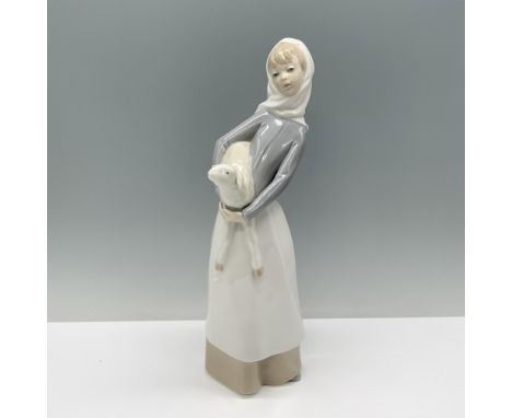 A woman in a gray shirt, tan skirt, and white head scarf cradles a lamb in her arms against her hip with tenderness. Lladro b