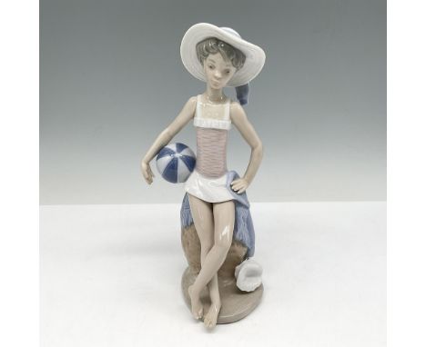 Young girl at beach with a beach ball, hat and seashell at her feet. Lladro backstamp. This item has its original box: 10"L x