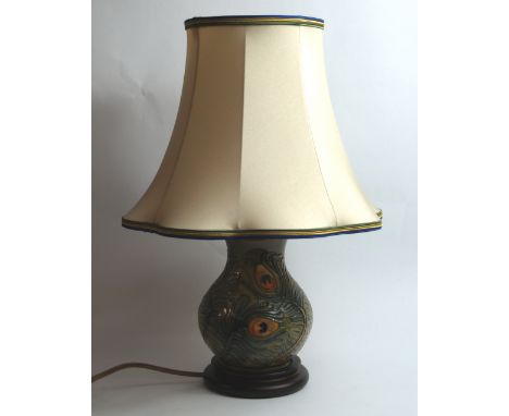 Moorcroft, a relief tube-line decorated electric table lamp with shade, raised on a mahogany plinth. Height (including shade)