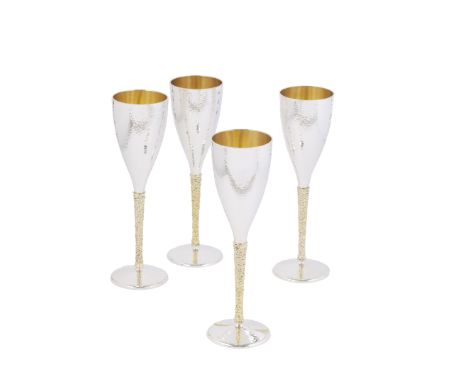 STUART DEVLIN: a set of four silver and silver-gilt champagne flutesLondon 1972 The tapering bowls with spot hammered surface