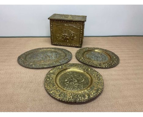 A pair of 19th century Dutch embossed brass chargers centred with wild boar hunting scenes within a border decorated with fru