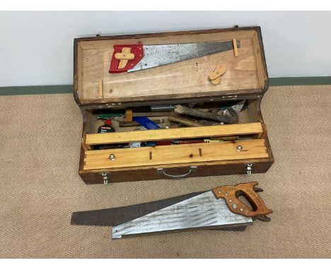 A quantity of tools within a wooden carpenters box, to include saws, hammers etc.