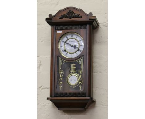 A mahogany cased 31 day wall clock with brass and enamel dial chiming on a coiled gong.