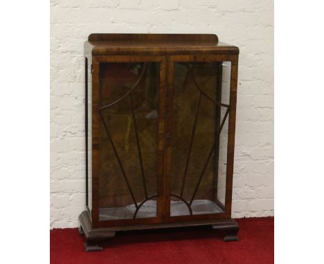 A walnut astrigal glazed two door china cabinet raised on bracket feet.