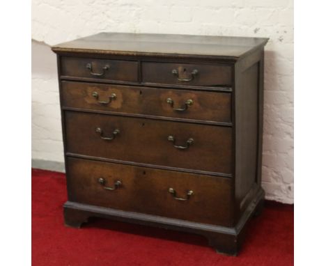 A George II oak two over three chest of drawers with panelled sides and raised on bracket feet.