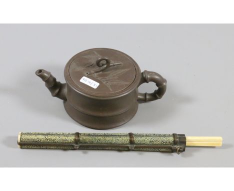 An oriental bronze and shark skin chopstick holder and ivory chopstick along with a Chinese red stone teapot.