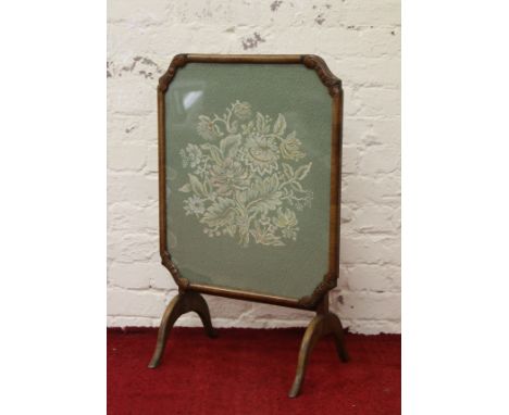 A carved walnut metamorphic firescreen occasional table raised on scroll supports.