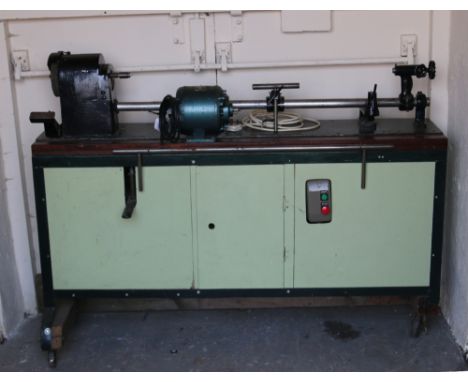 A steel cabinet/bench mounted with a wood turning lathe and spare 230 volt motor.