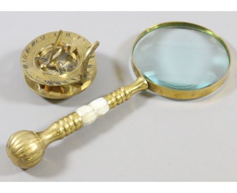 A decorative brass compass pseudo mark for F L West of London and a magnifying glass with mother of pearl style handle.