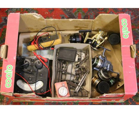 A box containing old engineering tools, volt meter pocket watch and fishing reels.