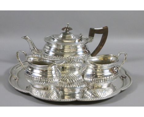 A serving tray and a three part silver plated tea service.