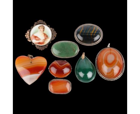A quantity of hardstone brooches and pendants, including hawks eye, malachite, banded agate, etc . Condition Report: Lot sold