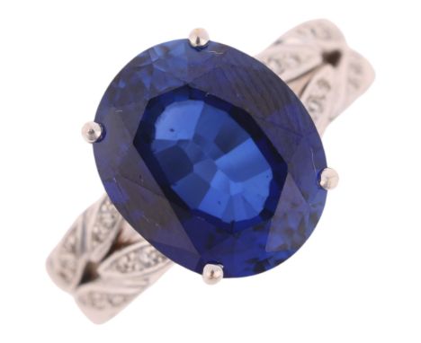An 18ct white gold synthetic sapphire and diamond dress ring, claw set with oval mixed-cut sapphire and modern round brillian