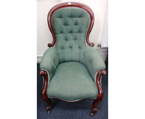 A Victorian mahogany spoon back armchair, button down upholstered in green, having scroll carved arms, on cabriole legs and c