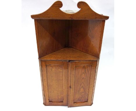 A late Victorian light oak wall hanging corner cabinet, with a recess above panelled doors, 53cm wide.