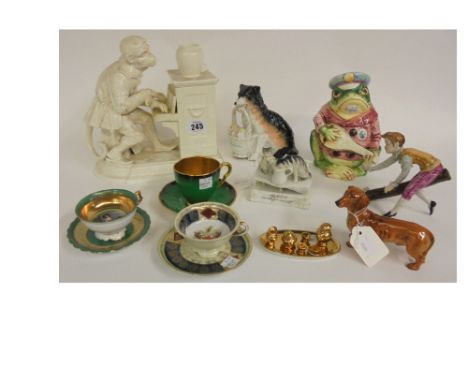 A Continental white glazed figure of an ape, seated, dressed at a piano, the lift-off cover concealing a compartment, 23cm wi