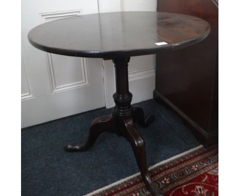 A George III mahogany tea table, the circular tilt-top on a bird cage and vase turned column tripod base, 75cm diameter.