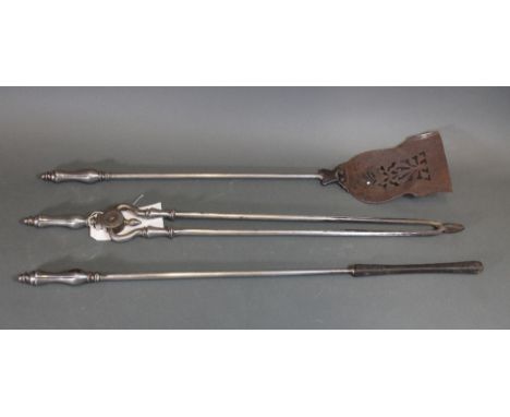 A set of three Victorian steel fire tools, with lotus capitals, 74cm long.