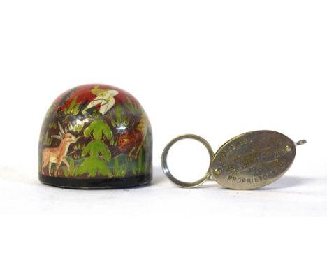 A Russian papier mache paperweight, 20th century, painted with a hunting scene, 5cm diameter and a combined compass and magni