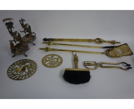 A set of three brass fire tools, with turned finials, a pair of electroplated mythological beast candlesticks, second half 19